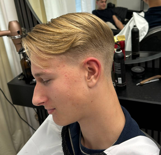 Kund med ljus fade och bakåtkammat hår hos Salong Hairstyle